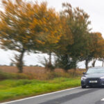 Voiture qui roule sur une voie avec des arbres sur le côté, effet photo vitesse